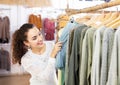 Brunette choosing skirt in shop Royalty Free Stock Photo