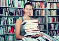 The brunette chose a lot of books in the university library Royalty Free Stock Photo