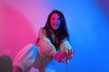 The brunette dances in neon, the dancer in red-blue. Hip hop girl, party, smile. Model in flight, jumping. Bright photo, emotions Royalty Free Stock Photo