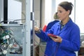 Brunette electrician holding calibrating device