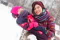 Brunette embracing daughter in winter