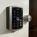 brunette entering code on keypad of home security alarm Video intercom next to alarm keypad