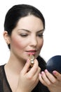 Brunette female applying lipstick in mirror