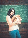 Brunette female student in classroom. young college girl walking with two heaps of books Royalty Free Stock Photo