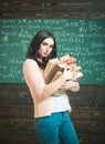 Brunette female student in classroom. young college girl walking with two heaps of books Royalty Free Stock Photo