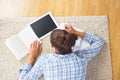 Brunette female student lying on the floor doing assignments Royalty Free Stock Photo