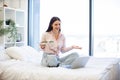 Brunette female talking by video call using laptop and eating healthy salad. Royalty Free Stock Photo