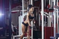 Brunette fitness girl in black sport wear with perfect body in gym