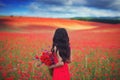 Brunette girl on the background of a blooming wild poppy field Royalty Free Stock Photo