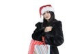 Brunette girl in black fur coat in santa attractive shopping bags on isolated background, christmas shopping, sale santa claus Royalty Free Stock Photo