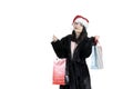 Brunette girl in black fur coat in santa hat with shopping bags on isolated background, christmas shopping, sale santa claus Royalty Free Stock Photo