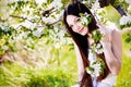 Brunette girl in blossom apple garden