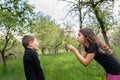 Brunette girl blowing on white dandelion on her little brother Royalty Free Stock Photo