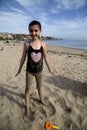 Brunette girl covered in sand on the beach