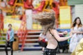 Brunette girl dancing on the street. Portrait of a beautiful blonde outdoors in a smart dress, lifestyle