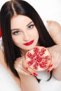 Brunette girl with garnet fruit in studio Royalty Free Stock Photo