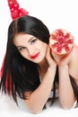 Brunette girl with garnet fruit in studio Royalty Free Stock Photo
