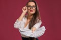 Brunette girl in glasses, wearing in a black short skirt and white blouse is posing holding a fan of hundred dollar Royalty Free Stock Photo