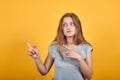 Brunette girl in gray t-shirt over isolated orange background shows emotions Royalty Free Stock Photo