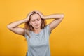 Brunette girl in gray t-shirt over isolated orange background shows emotions Royalty Free Stock Photo