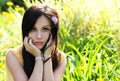 Brunette girl on green grass at summer park. Portrait of young beautiful woman Royalty Free Stock Photo