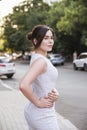 Brunette girl in grey smark casual dress walking in european city. copy space Royalty Free Stock Photo