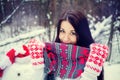 Brunette girl in hat and mittens sculpts a snowman