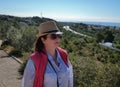 Brunette girl in a hat and sunglasses looks at the road away Royalty Free Stock Photo