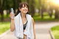 Brunette girl holding bottle of water after sport in park Royalty Free Stock Photo