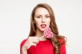 The brunette girl is holding a lollipop as a heart . For Valentine`s Day. On white background Royalty Free Stock Photo