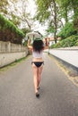 Brunette girl holding surfboard over head and walking Royalty Free Stock Photo