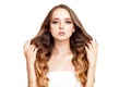 Brunette girl with long and shiny long hair . Beautiful model woman with curly hairstyle and fashionable makeup. Royalty Free Stock Photo