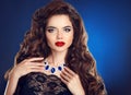 Brunette girl with long shiny wavy hair and red lips makeup, fashion necklace jewelry. Beautiful model with curly hairstyle Royalty Free Stock Photo