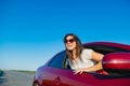 Brunette girl look out from red car