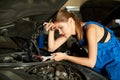 Brunette girl mechanics repairing or inspecting a car