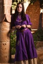 Brunette girl in a medieval suit in a Agia Napa Medieval Monastery