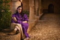 Brunette girl in a medieval suit in a Agia Napa Medieval Monastery