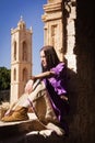 Brunette girl in a medieval suit in a Agia Napa Medieval Monastery