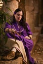 Brunette girl in a medieval suit in a Agia Napa Medieval Monastery