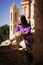 Brunette girl in a medieval suit in a Agia Napa Medieval Monastery