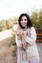 brunette girl in a scarf drinks hot tea from a mug