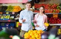 Brunette girl and smiling boyfriend buying citruses Royalty Free Stock Photo