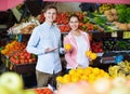 Brunette girl and smiling boyfriend buying citruses Royalty Free Stock Photo