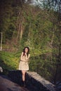 Brunette girl stands on the bridge near the water Royalty Free Stock Photo