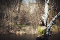 Brunette girl stands by the tree near the water Royalty Free Stock Photo