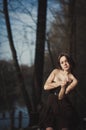 Brunette girl stands by the tree near the water Royalty Free Stock Photo