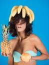 Brunette girl in swimsuit with banana, grapefruit, pineapple