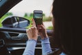 Brunette girl travel the roads in a car, take pictures with the phone. Vacation concept Royalty Free Stock Photo