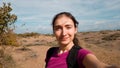 Brunette girl walking on a deserted field and takes a selfie. Traveler in Turkey