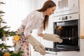 The girl puts a baking tray with Christmas cookies in the oven Royalty Free Stock Photo